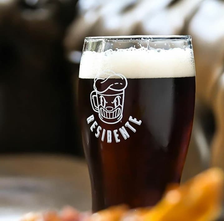 Pinta de cerveza con el logo de Residente